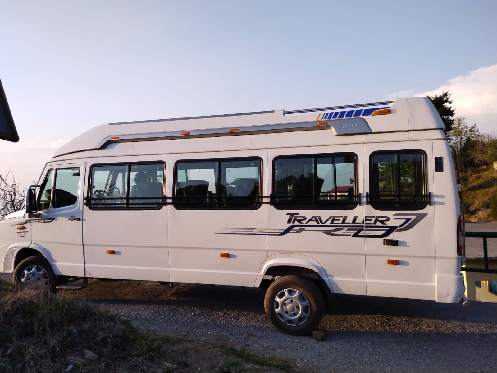 White tourist van side profile - Reliable tourist vehicle for outstation trips from Delhi